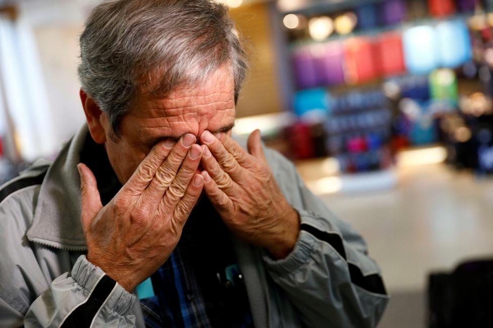 مهاجر يبكي في مطار لوس انجلوس الدولي بسبب قرار ترامب الظالم