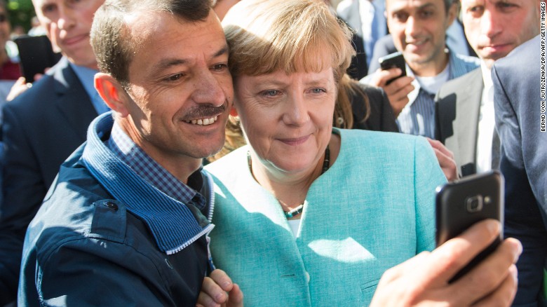المستشارة الالمانية تلتقط صورة سيلفي مع لاجئ سوري في برلين 