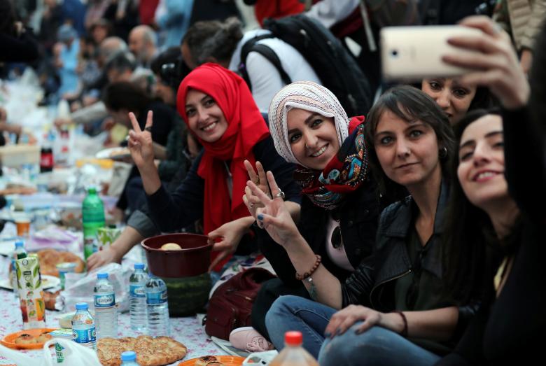 مسلمات يلتقطنّ سيلفي قبل أن يشرعن في كسر صيامهن في ساحة استقلال وسط اسطنبول- تركيا، 