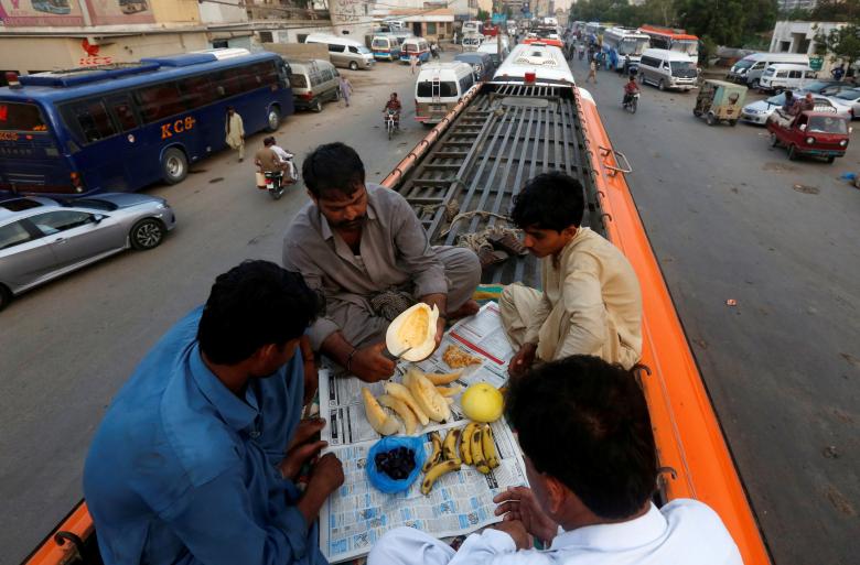 رجال باكستانيون يستعدون لكسر صيامهم على ظهر حافلة في كراتشي 