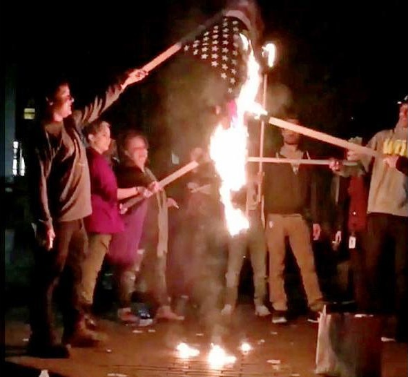 Manifestantes anti-Trump prenden fuego a bandera de EEUU