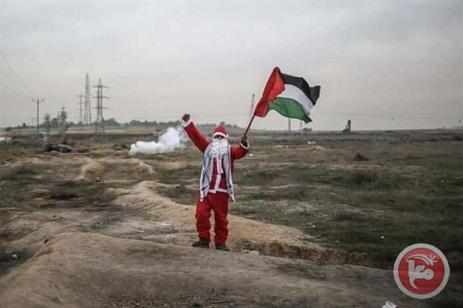 "بابا نويل" يرفع العلم الفلسطيني على حدود غزة (صور)