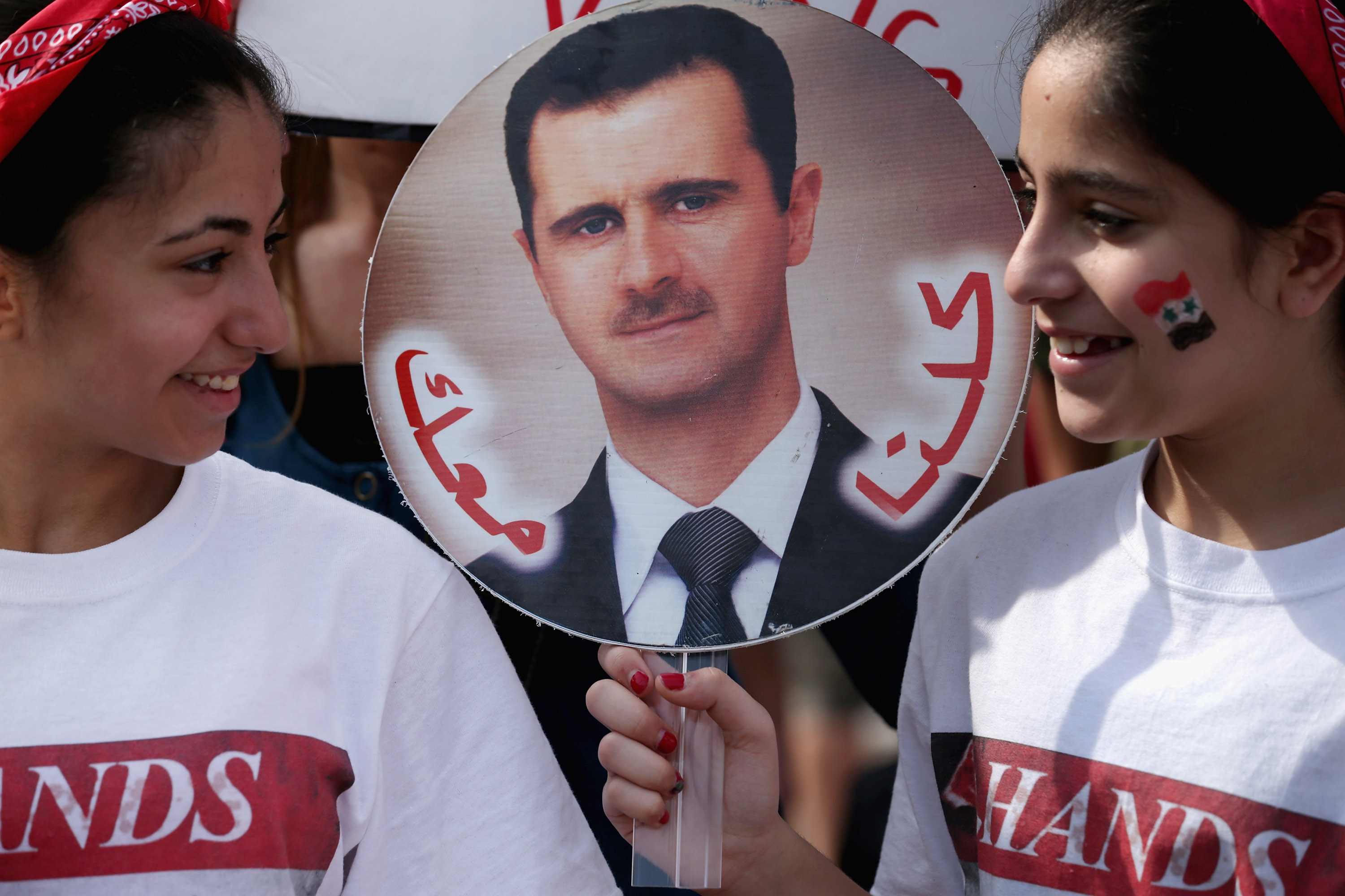 فتيات سوريات يحملن صورة الرئيس السوري بشار الأسد في واشنطن